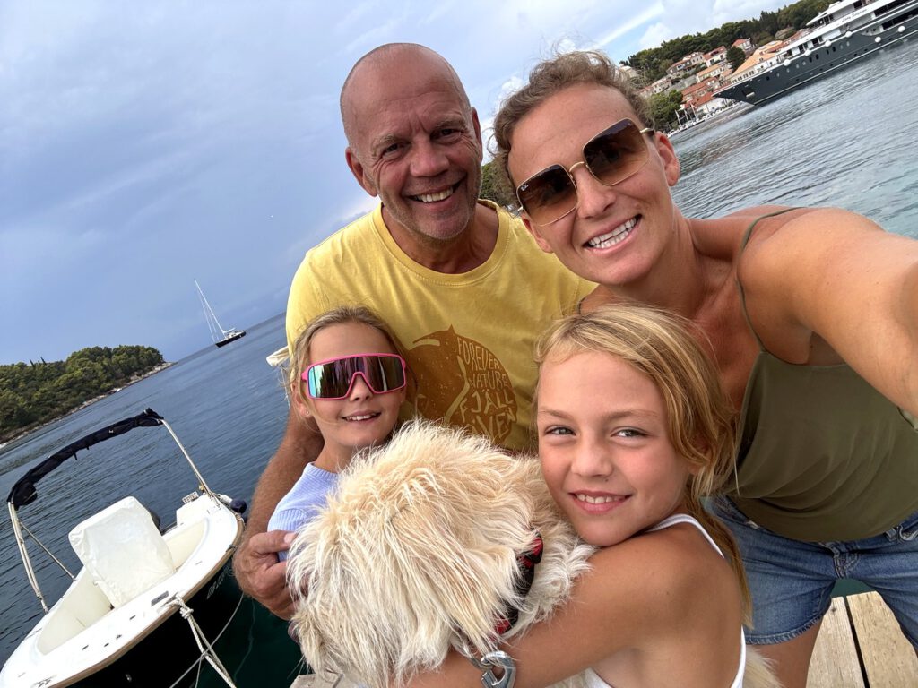 Familie mit Hund beim Selfie auf dem Bootssteg