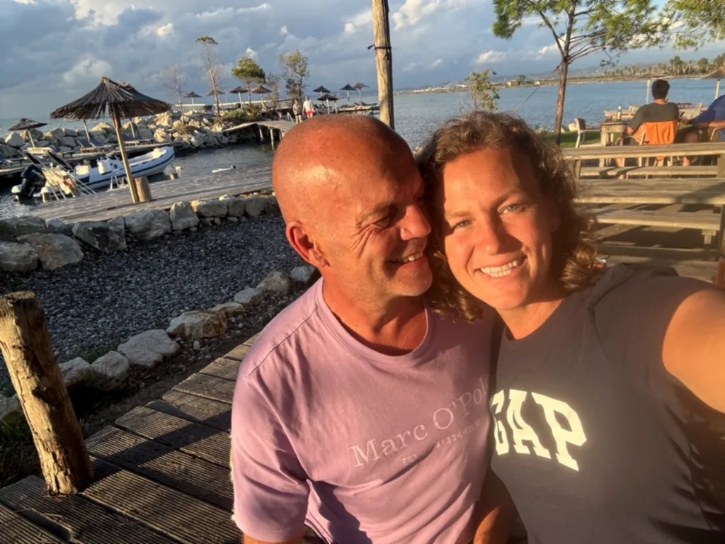 Selfie von Heiner und Lisa lachend auf der Holzterrasse des Inselrestaurants