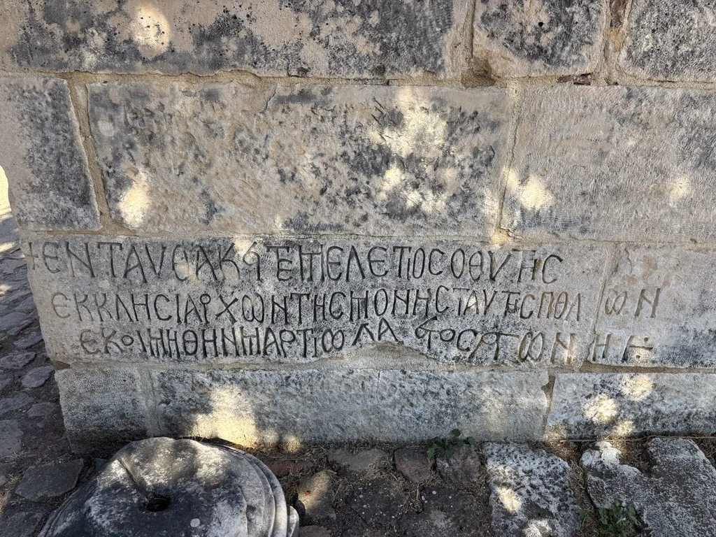 In einen Steinblock gemeißelte griechische Inschrift an einer Mauer in Apollonia
