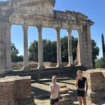 Franziska und Anna essen Eis vor der Säulenfassade des Buleuterions in Apollonia