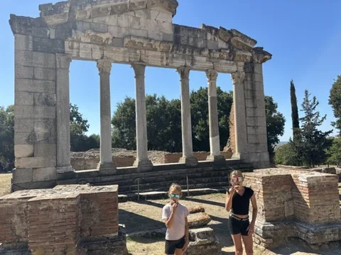 Franziska und Anna essen Eis vor der Säulenfassade des Buleuterions in Apollonia